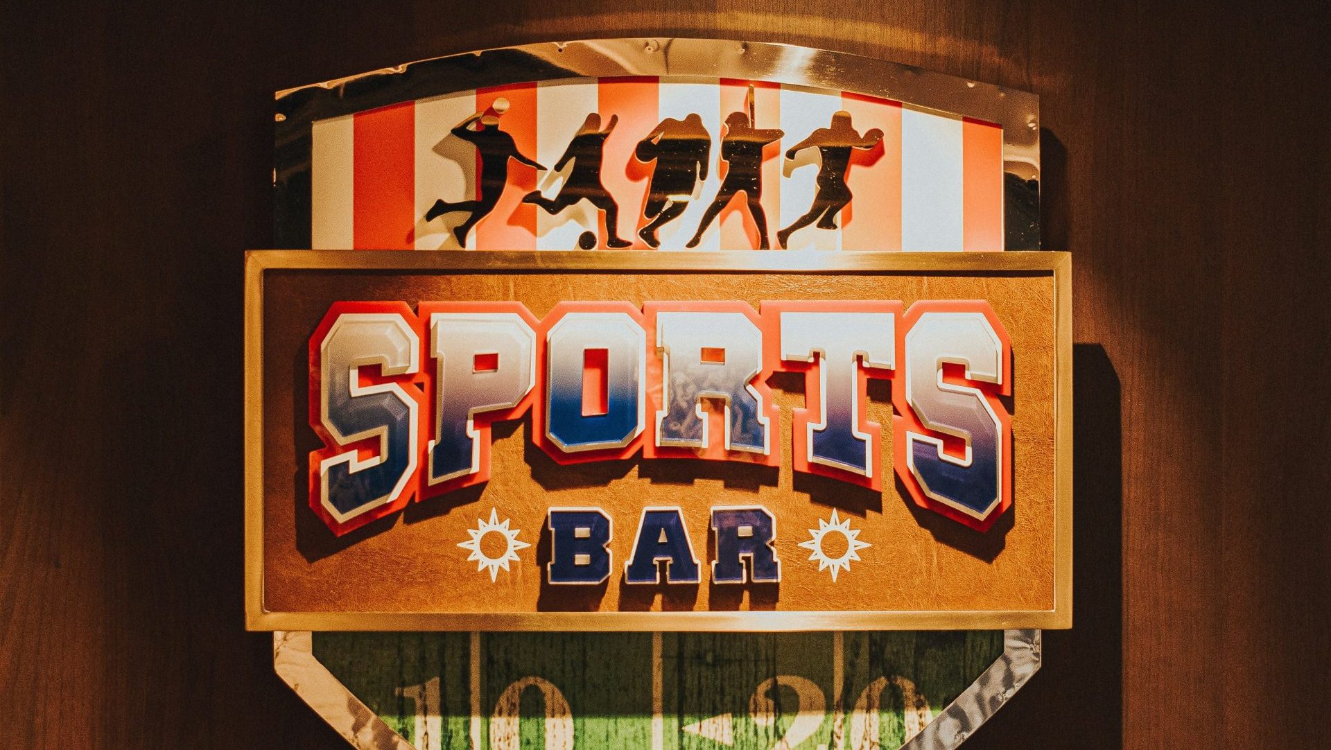 a sports bar sign mounted on a wooden wall